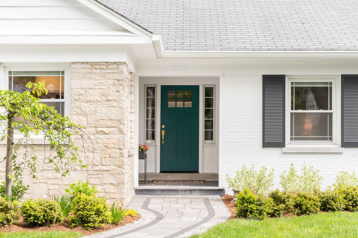 beautiful family house shingle roof white siding rock wall green door